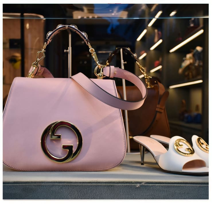 A pink purse and white shoes on display.