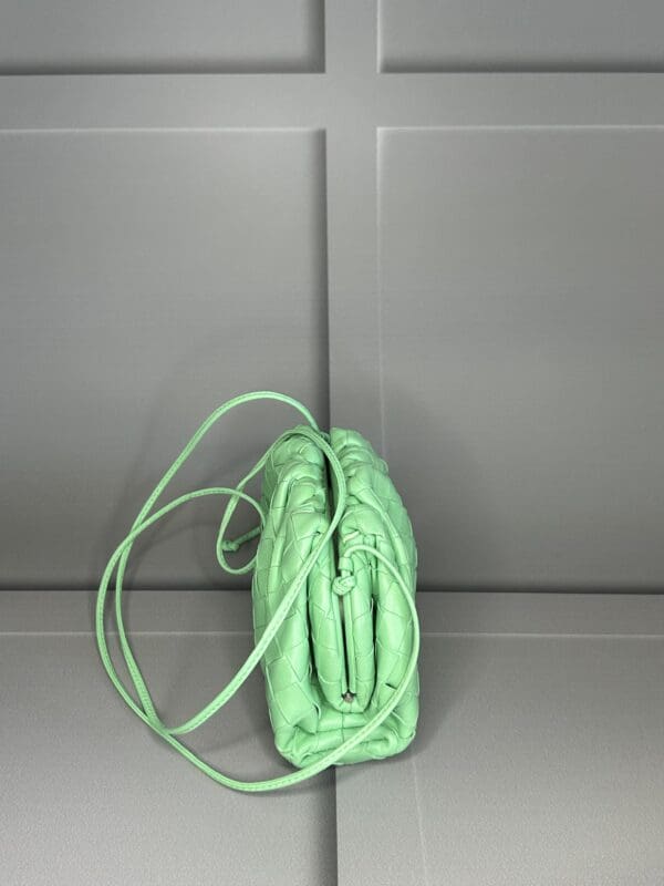 A green purse sitting on top of a counter.