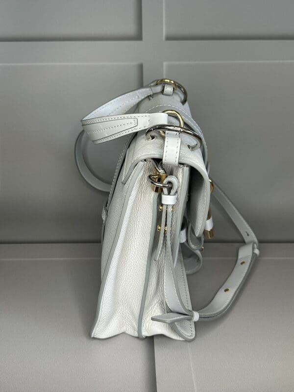 A white purse hanging on the wall