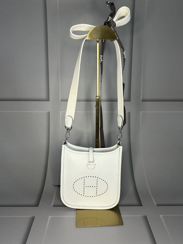 A white purse hanging on the wall