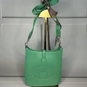 A green purse is hanging on the wall.