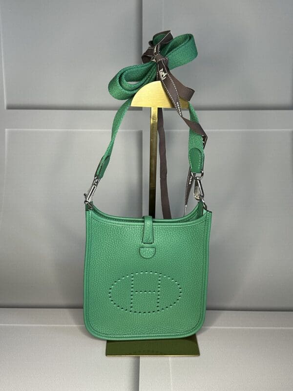 A green purse is hanging on the wall.