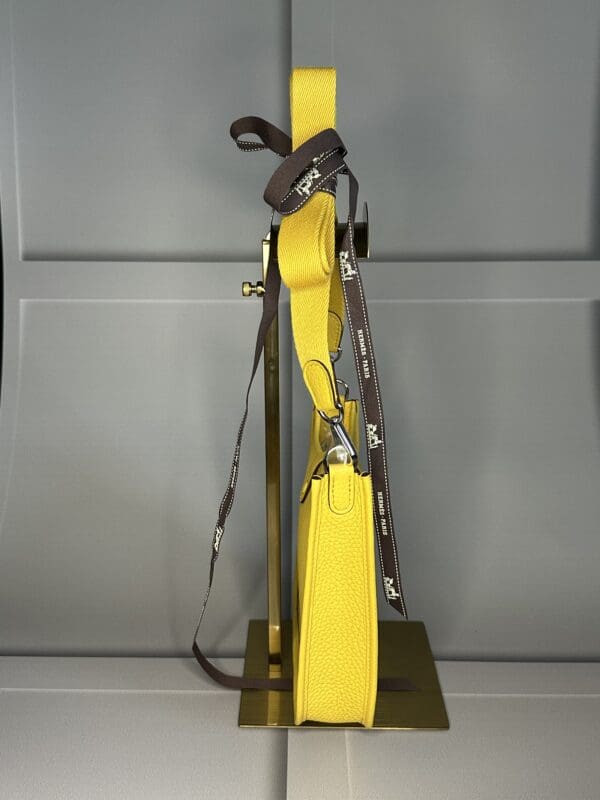 A yellow pole with some straps hanging from it