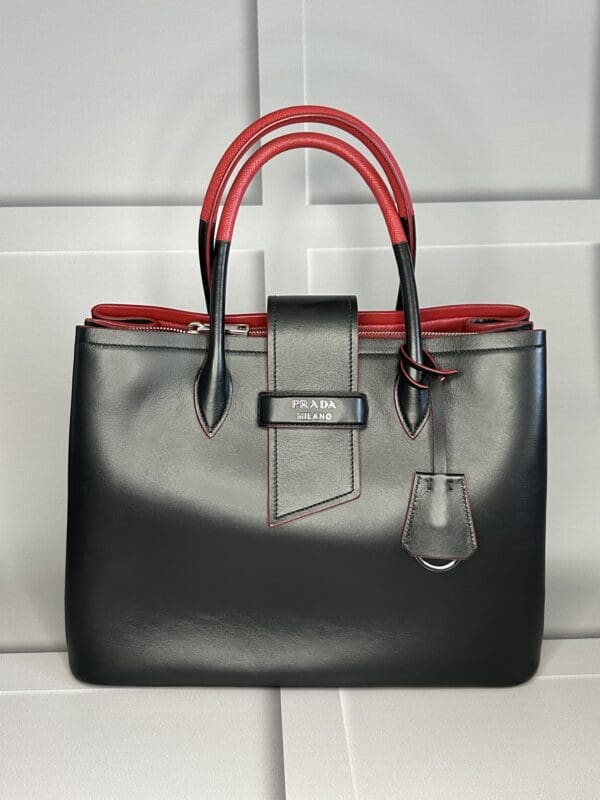 A black and red purse sitting on top of a counter.